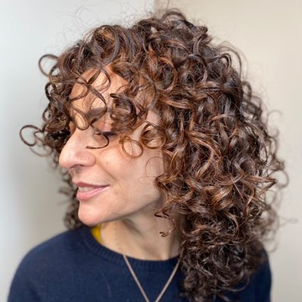 Donna con capelli ricci curati con trattamenti e prodotti bio