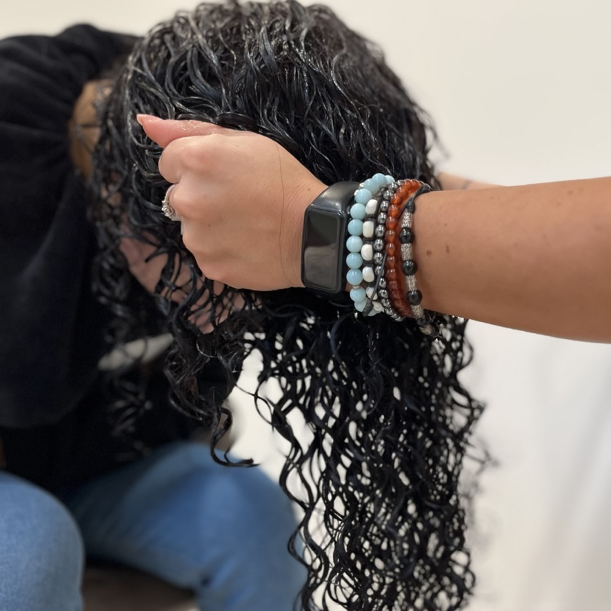 Parrucchiera strizza i capelli di una donna per dare uno stile ai capelli