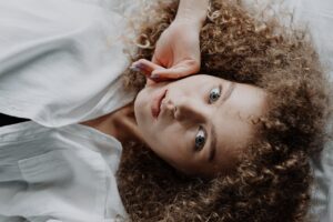 Ragazza con capelli ricci sani e voluminosi