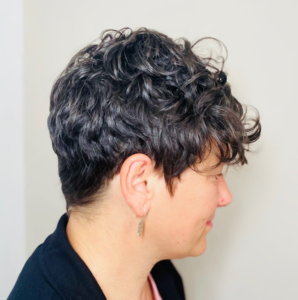 Donna con taglio capelli ricci cortissimi