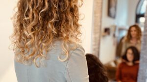 Parrucchiera misura la lunghezza dei capelli di una cliente prima del taglio