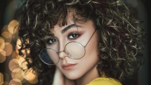 Ragazza con capelli ricci medi e occhiali
