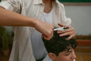 Barbiere esegue un taglio capelli ricci uomo