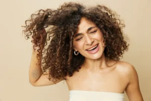donna si pettina i capelli ricci con difficoltà