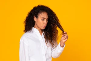 donna che tocca i suoi capelli secchi