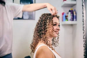 specialista capelli ricci acconcia i capelli di una cliente