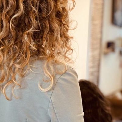 Parrucchiera misura la lunghezza dei capelli di una cliente prima del taglio