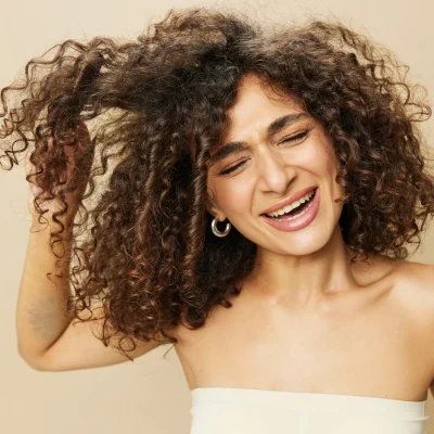 donna si pettina i capelli ricci con difficoltà