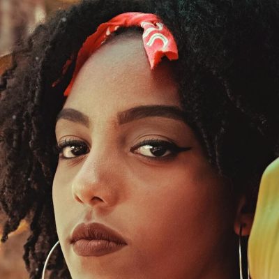 Donna con capelli ricci e bandana rossa