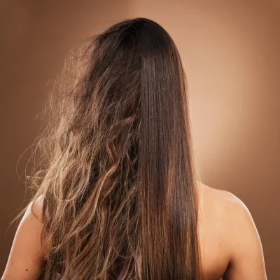 Donna di spalle con capelli lunghi metà lisci e metà rovinati