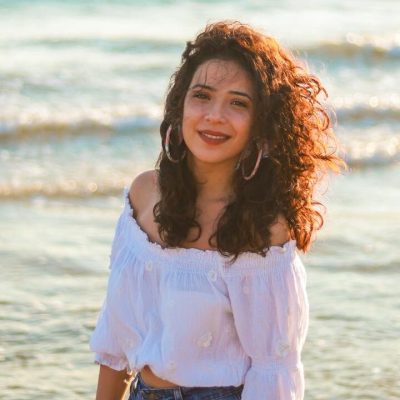Donna al mare con capelli ricci lunghi