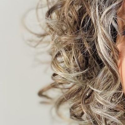 Donna con capelli ricci sale e pepe