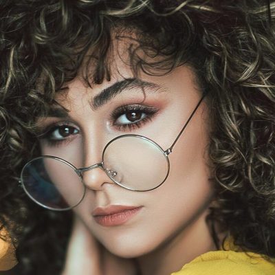 Ragazza con capelli ricci medi e occhiali
