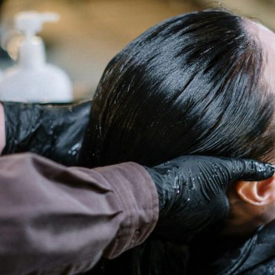 Parrucchiere lava capelli neri di una donna in lavatesta