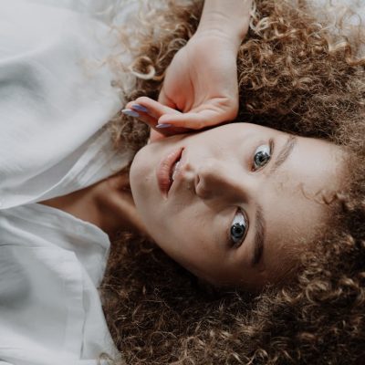 Ragazza con capelli ricci sani e voluminosi