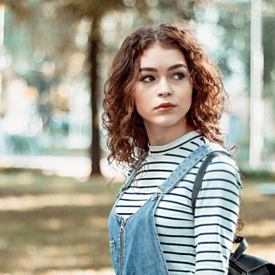 Ragazza all'aperto con capelli medi ricci