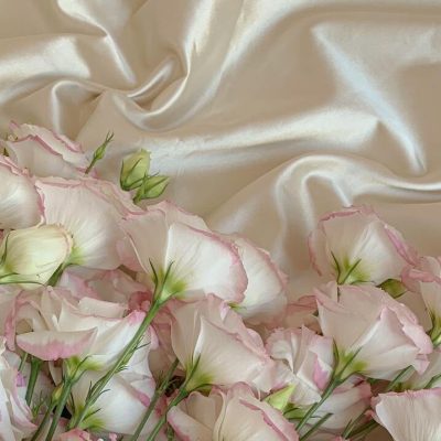 Fiori di lisianthus rosa e bianchi su tessuto di raso
