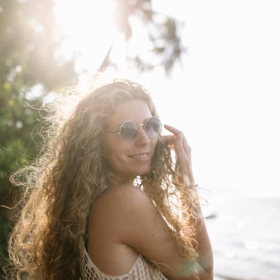 Donna con capelli lunghi ricci e occhiali da sole