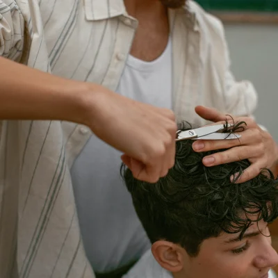 Barbiere esegue un taglio capelli ricci uomo